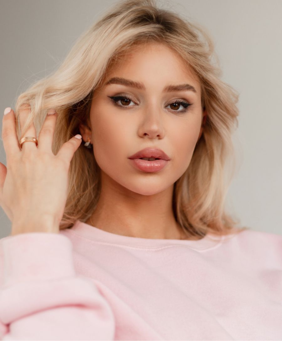 Newport Beach kybella model wearing a pink sweater